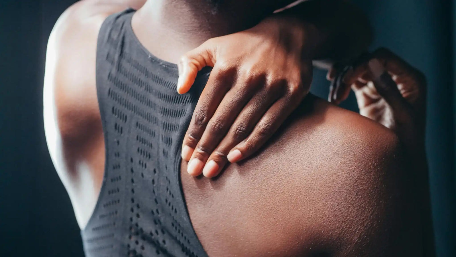 Close-up of athlete massaging sore shoulder muscles demonstrating how to recover muscles faster after workout.